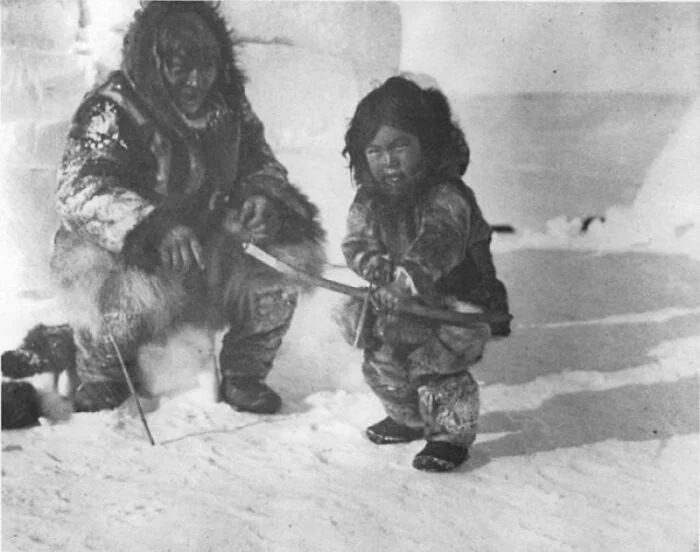 Инуит учит мальчика стрелять из лука. Примерно 1920 год