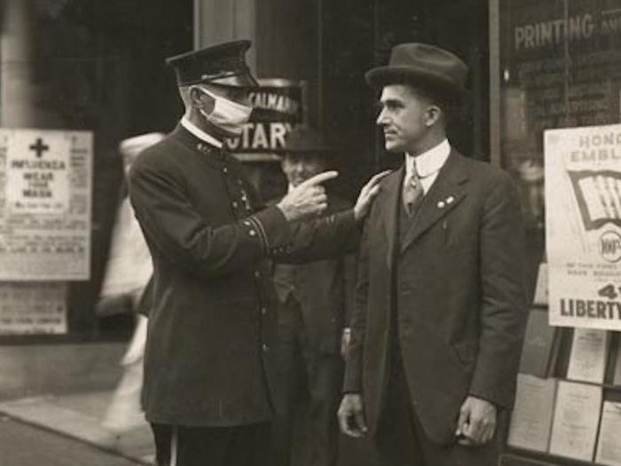 Полицейский в Сан-Франциско журит мужчину за то, что тот не носит маску во время пандемии гриппа в 1918 году